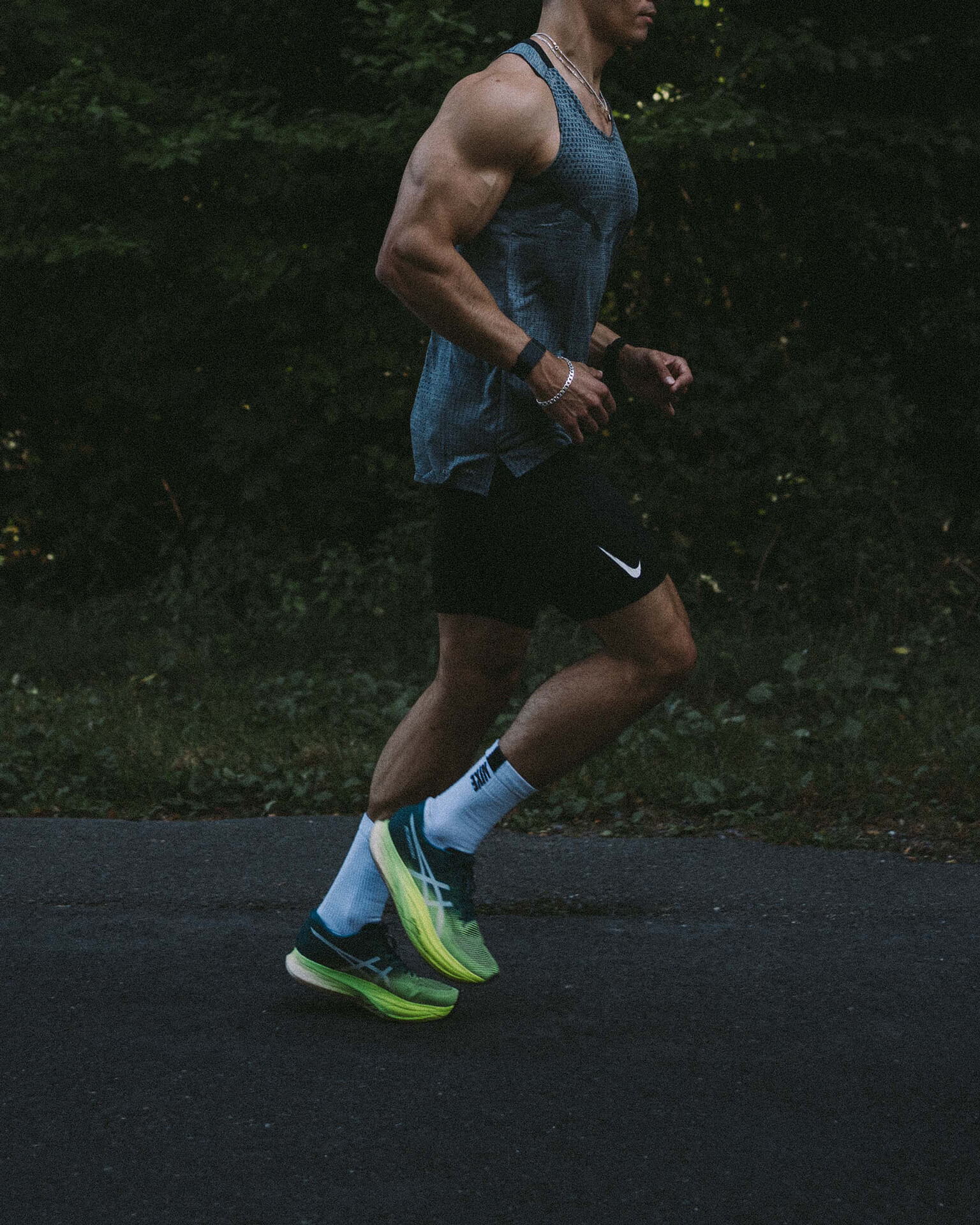 Image of a fitness male running outdoors on pavement wearing athletic wear